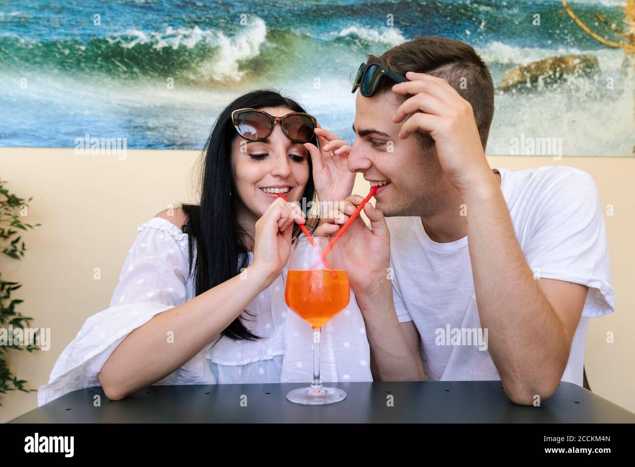 Happy young couple sharing an aperitif Stock Photo