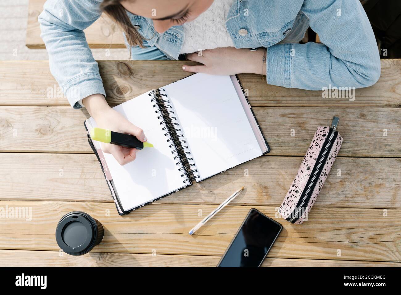Student with felt tip pen and book at table Stock Photo