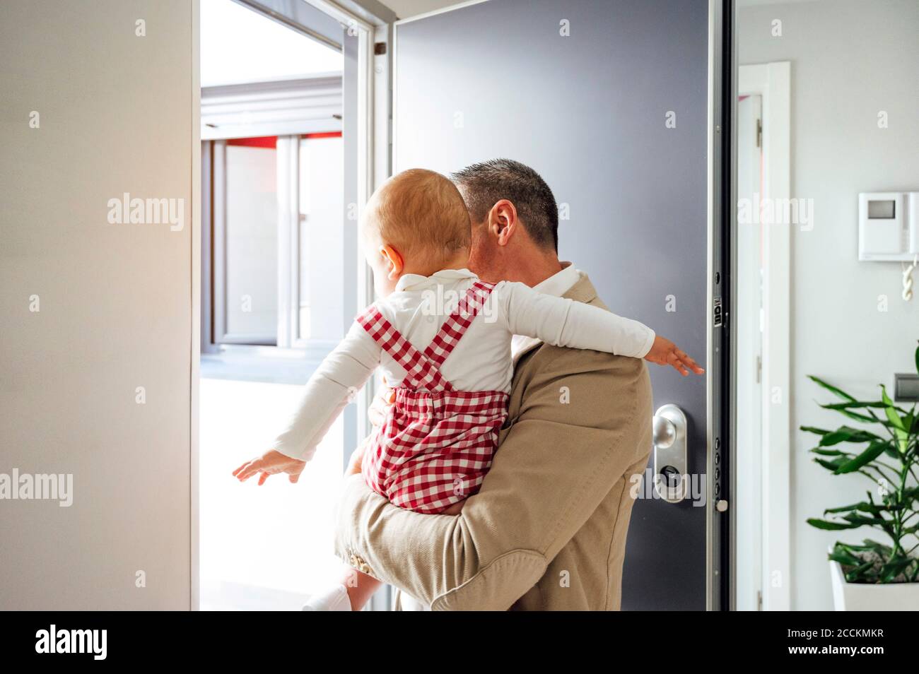 Father holding his baby boy and leaving home Stock Photo