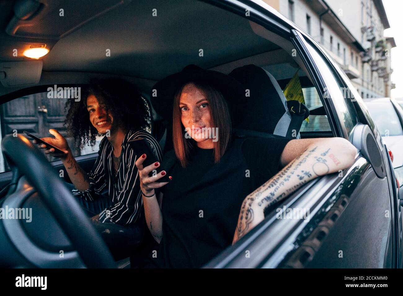 Couple using smart phones while sitting in car seen through window Stock Photo
