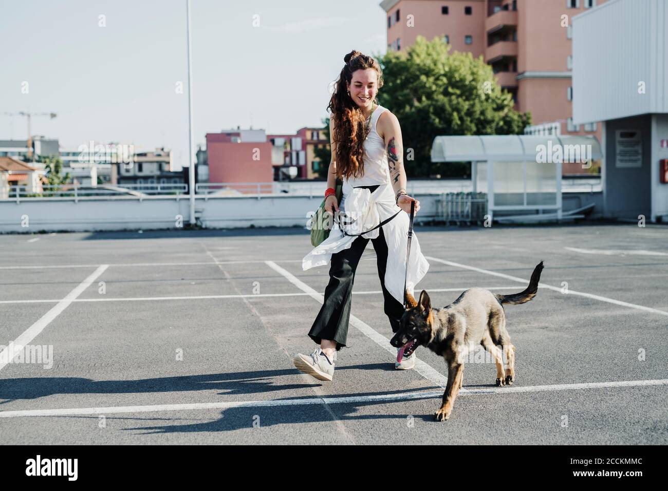Woman walking with dog in parking lot Stock Photo