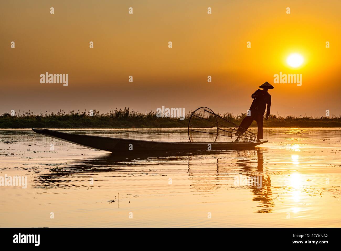 Myanmar, Shan state, Silhouette of traditional Intha fisherman on Inle lake at sunset Stock Photo