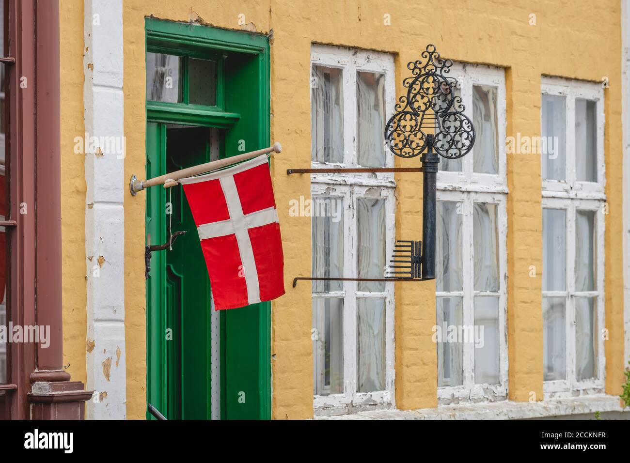 Danish flag hanging outside old building Stock Photo