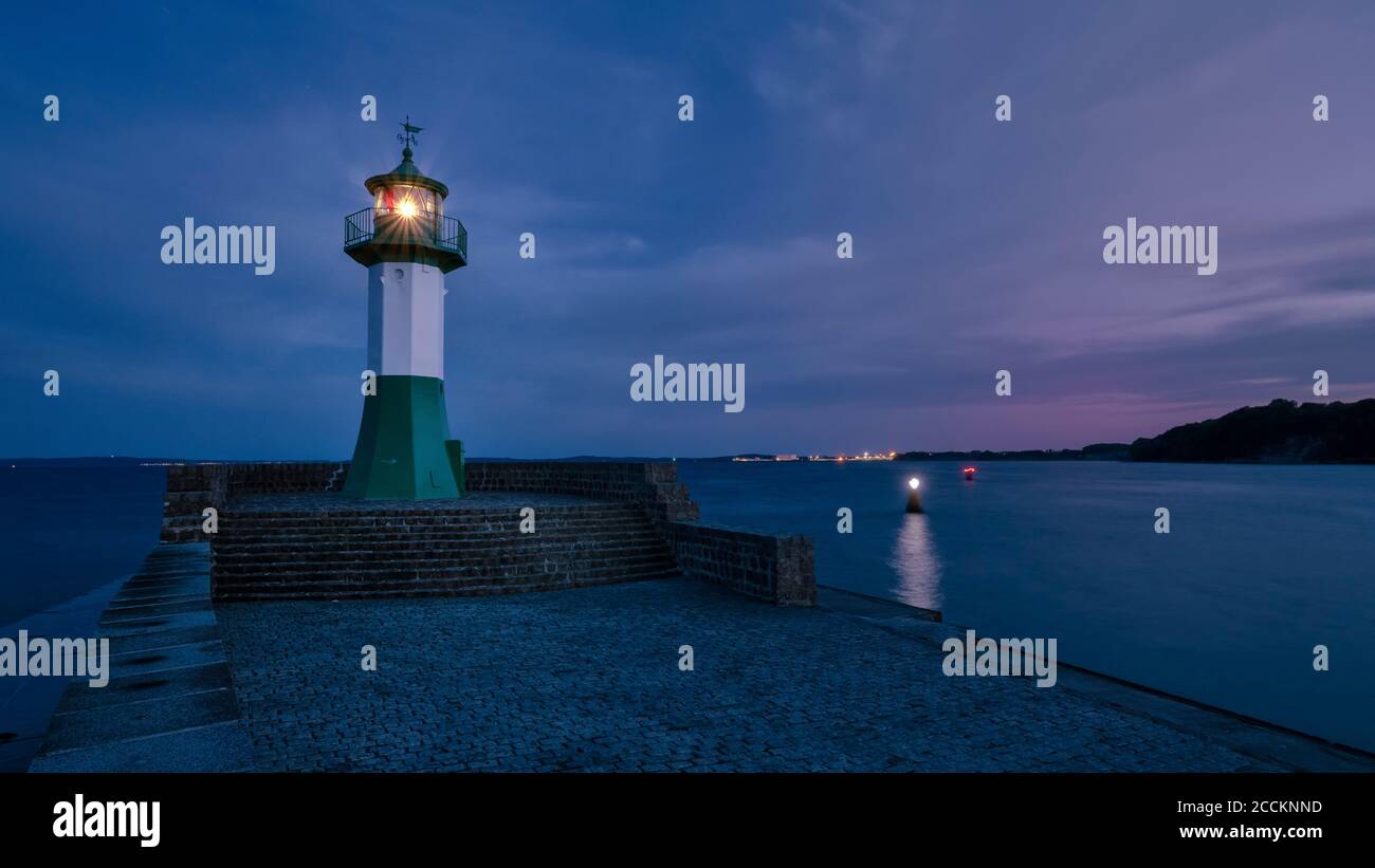 Germany, Mecklenburg-Western Pomerania, Sassnitz, Small lighthouse on shore of Rugen island at night Stock Photo