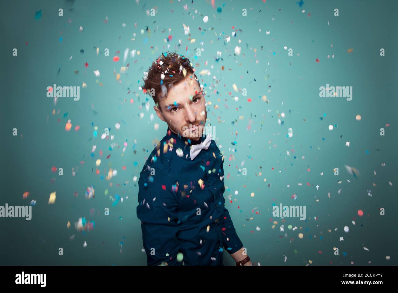 Portrait of young serious man throwing confetti Stock Photo Alamy