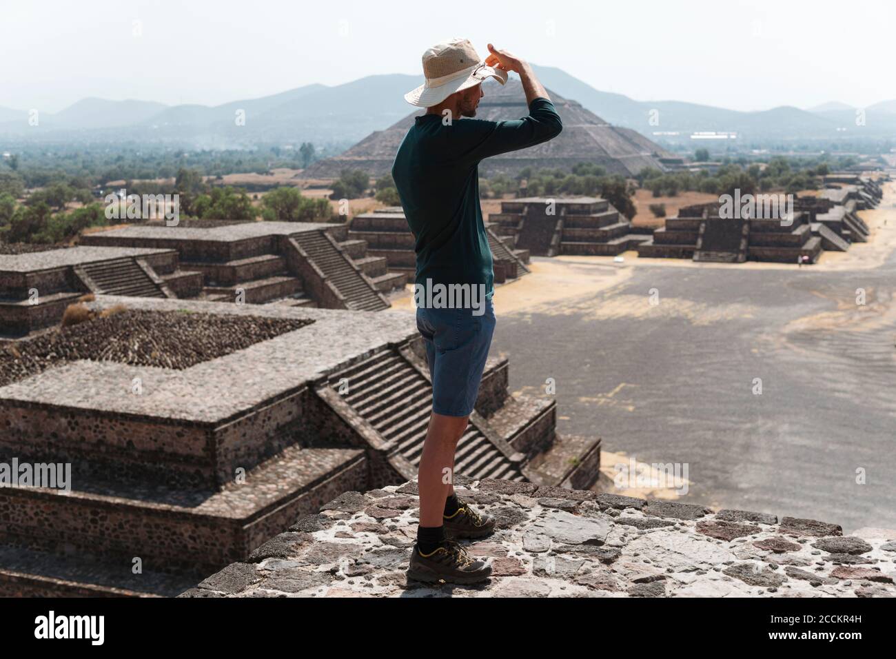 Mature man wearing hat standing on pyramid against sky in Teotihuacan, Mexico Stock Photo