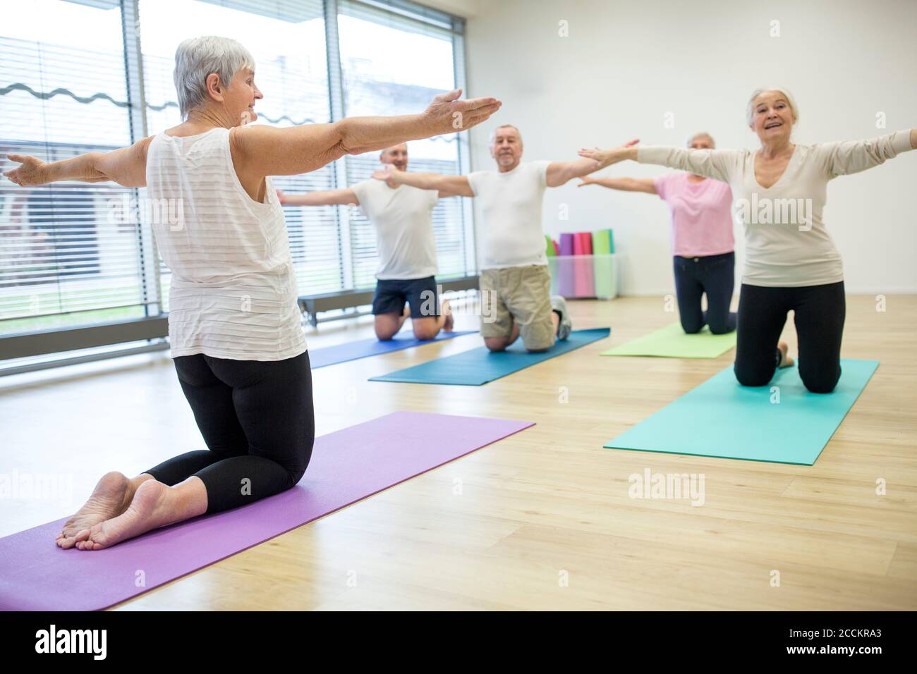 Group of active seniors practicing yoga together Stock Photo