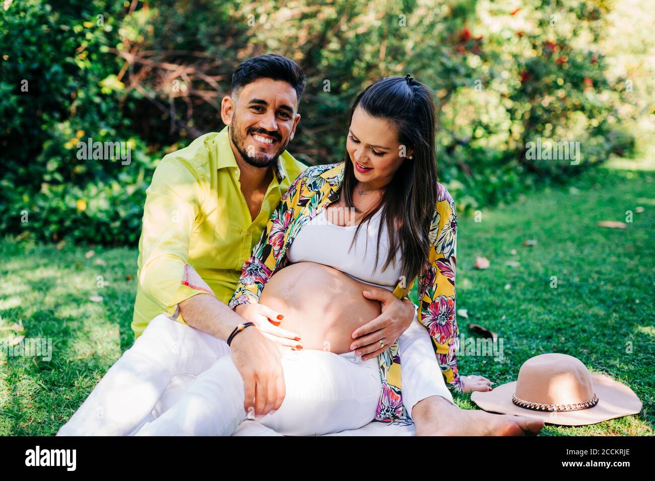 Happy man with pregnant woman relaxing at public park Stock Photo - Alamy