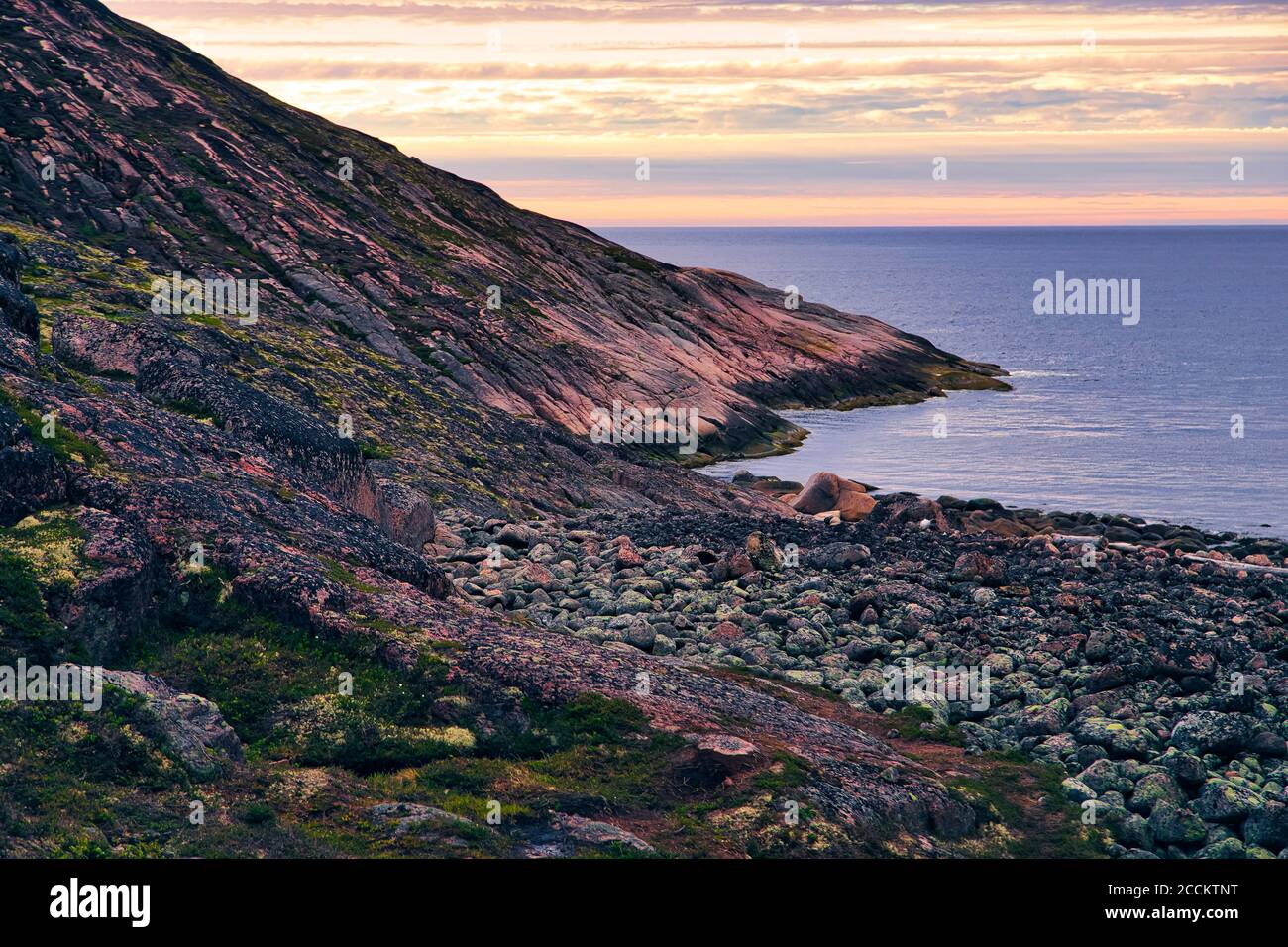 Rocky shore of Barents Sea at dusk Stock Photo