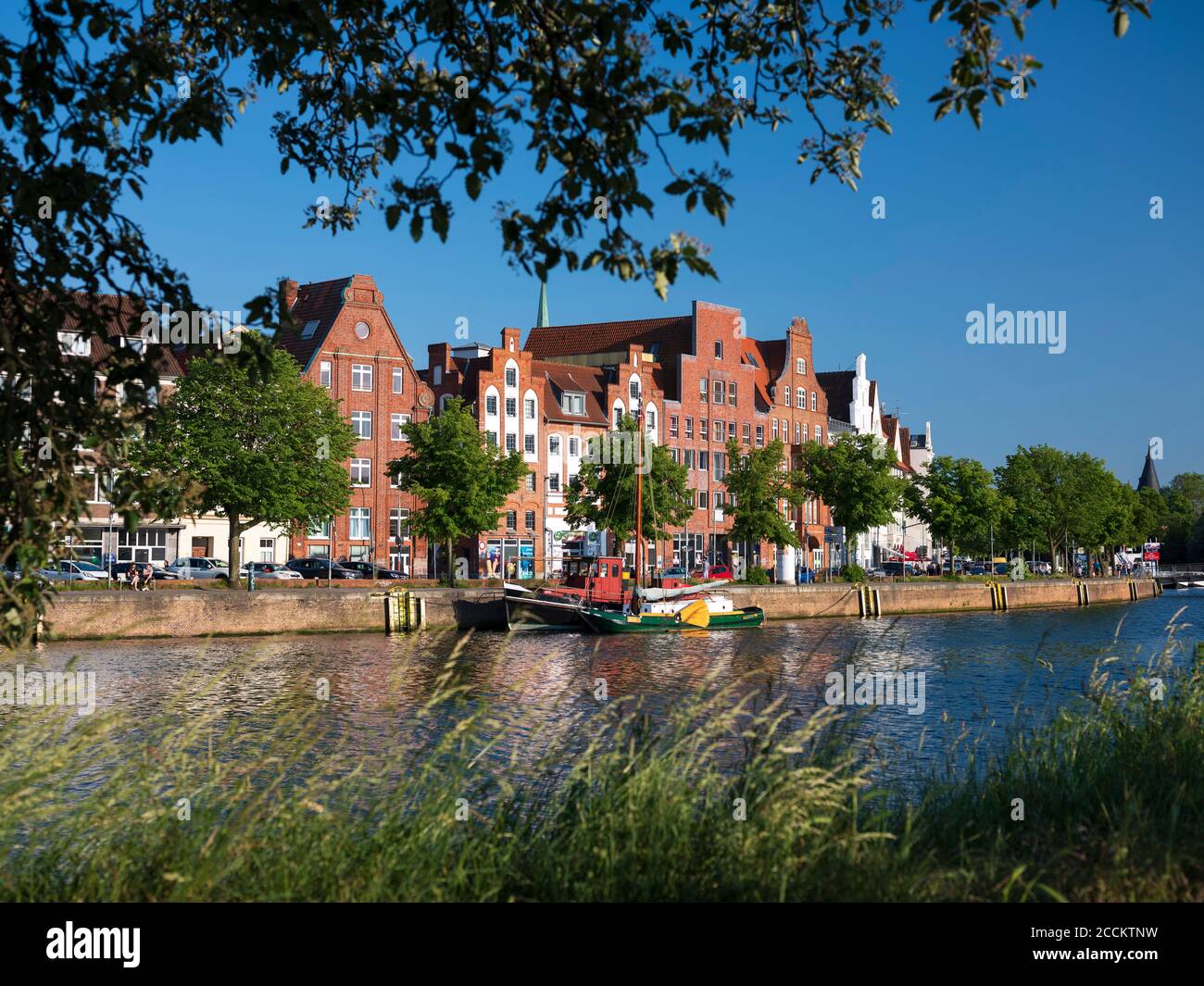Germany, Schleswig-Holstein, Lubeck, Boat moored in front of Salzspeicher warehouses Stock Photo