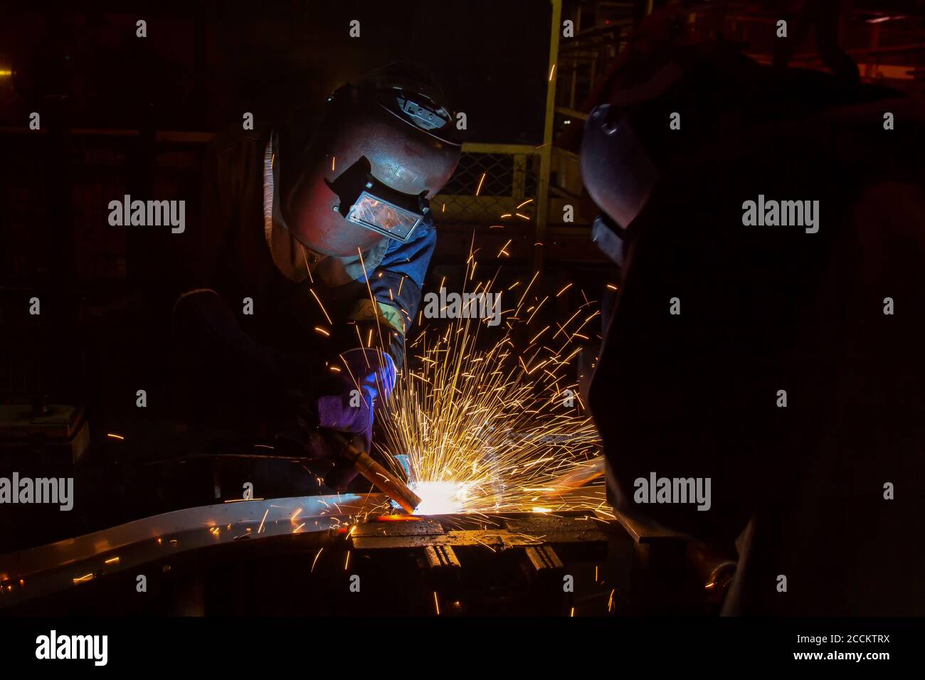 Team welders are welding in factory Stock Photo