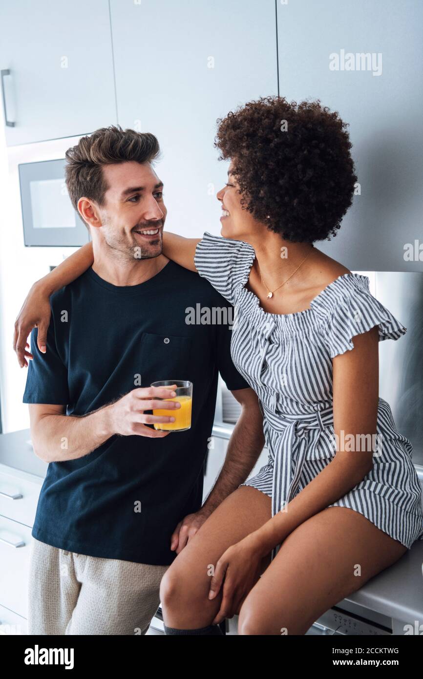 Affectionate multi-ethnic couple in kitchen of penthouse Stock Photo