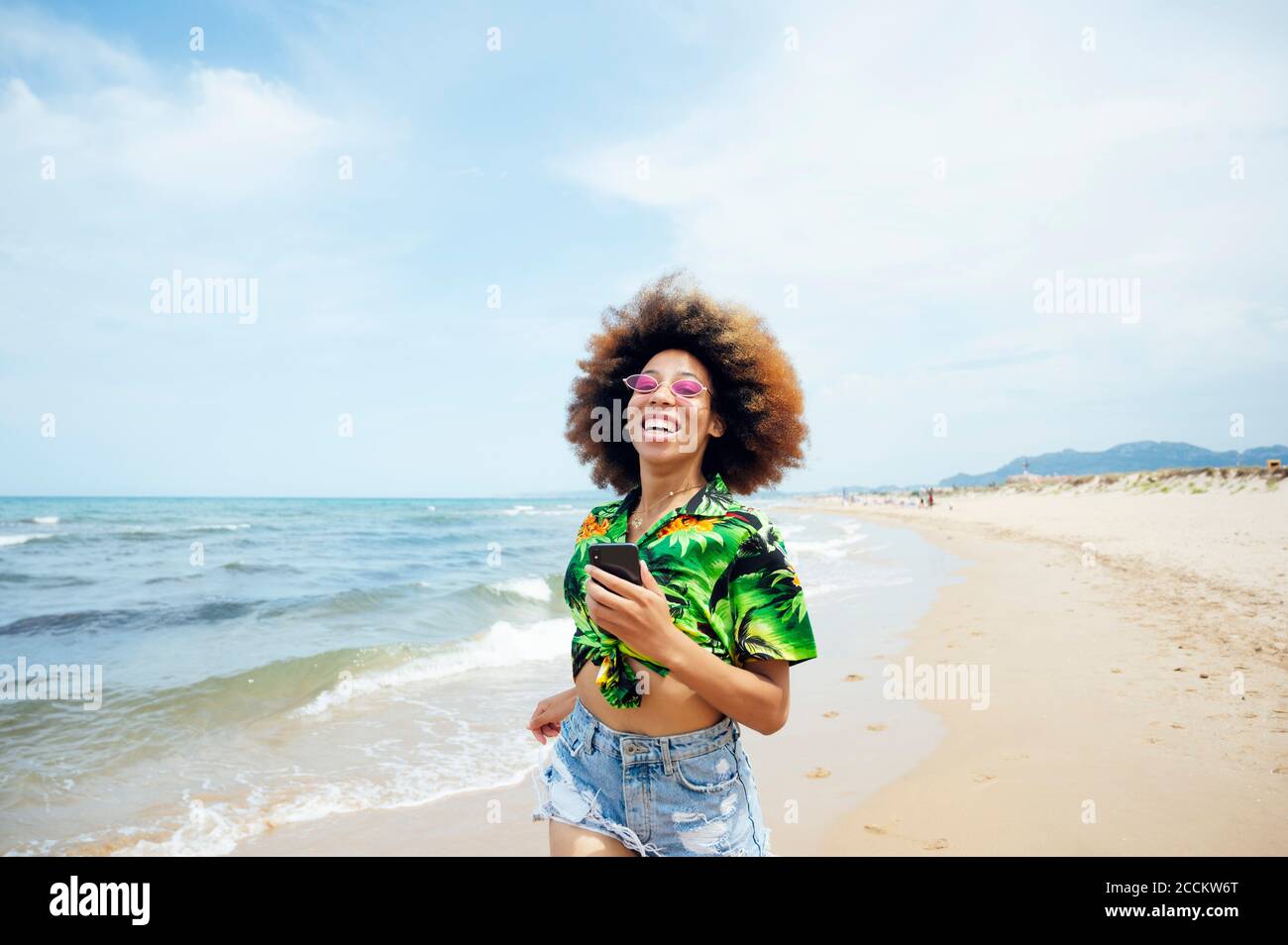 Happy young woman running at the beach Stock Photo