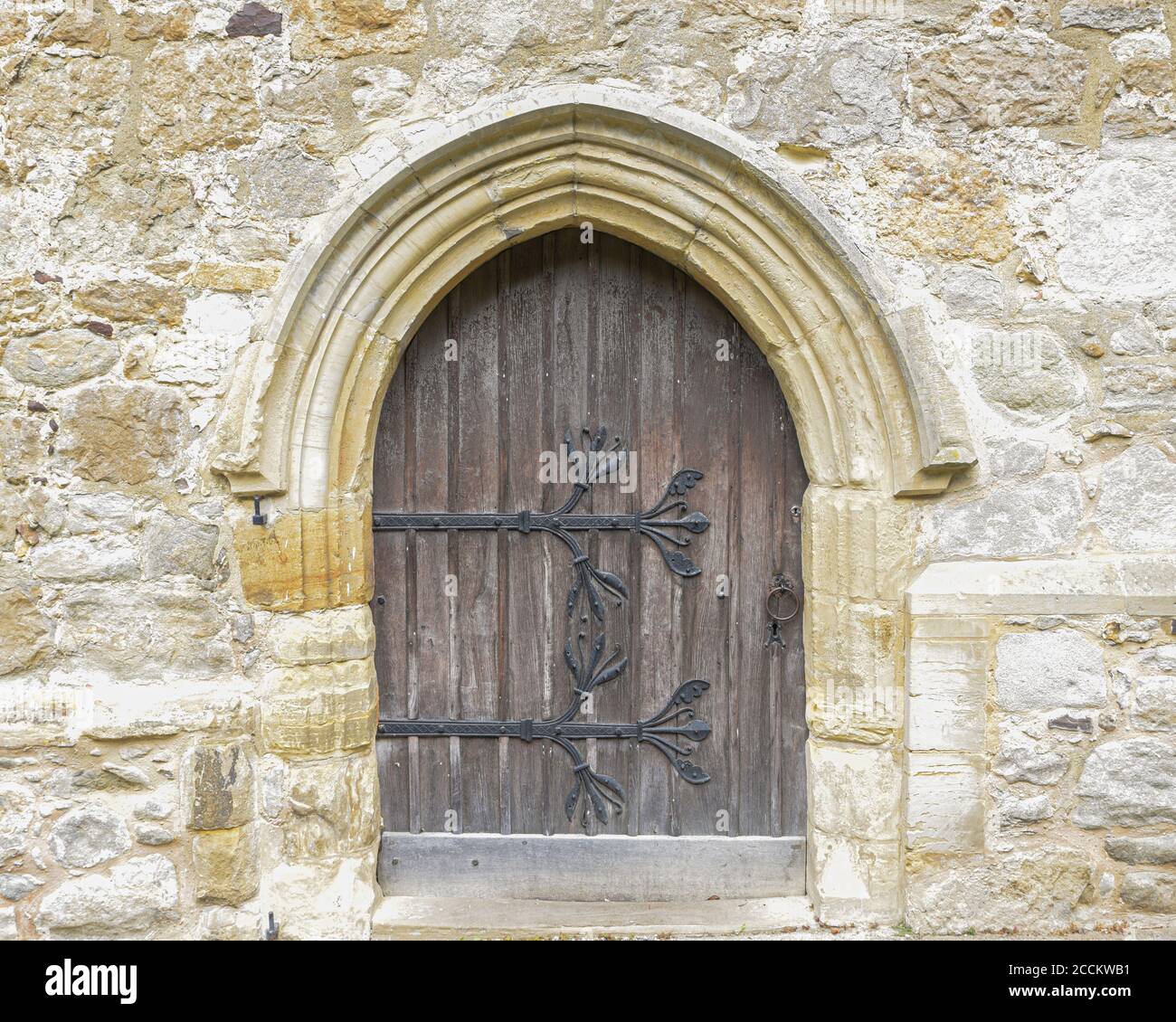 Old wooden door with large iron hinges in a wall of a church Stock ...