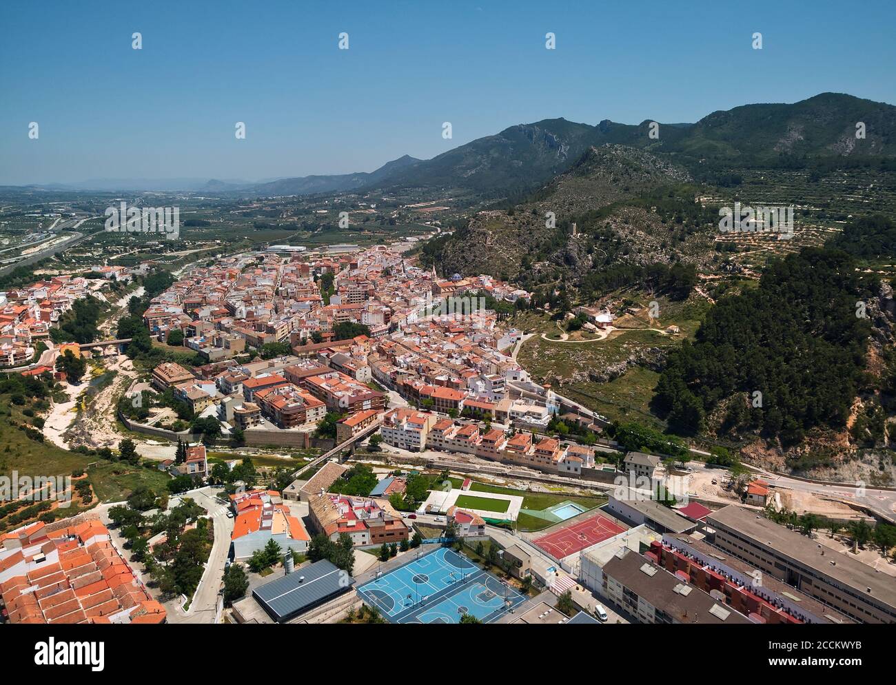 Moixent spanish townscape view from above, picturesque view to mountains and residential buildings drone point of view, sunny summer day. Spain Stock Photo
