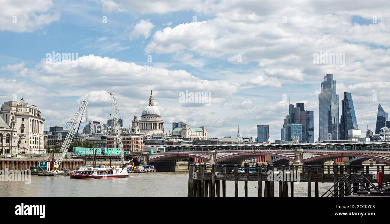 River Thames, London, 2020 Panoramic view of River Thames on a summer day.  The City is virtually empty apart from a cruise boat taking pasengers down Stock Photo