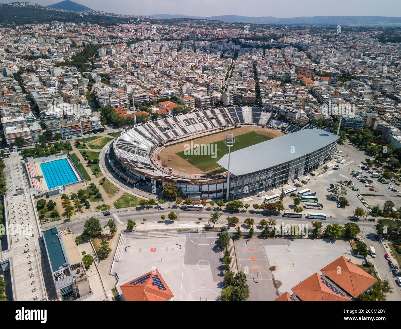 Thessaloniki, Greece landscape drone shot of PAOK FC Toumba stadium.Aerial top day view of empty football court with green pitch &  team name written. Stock Photo