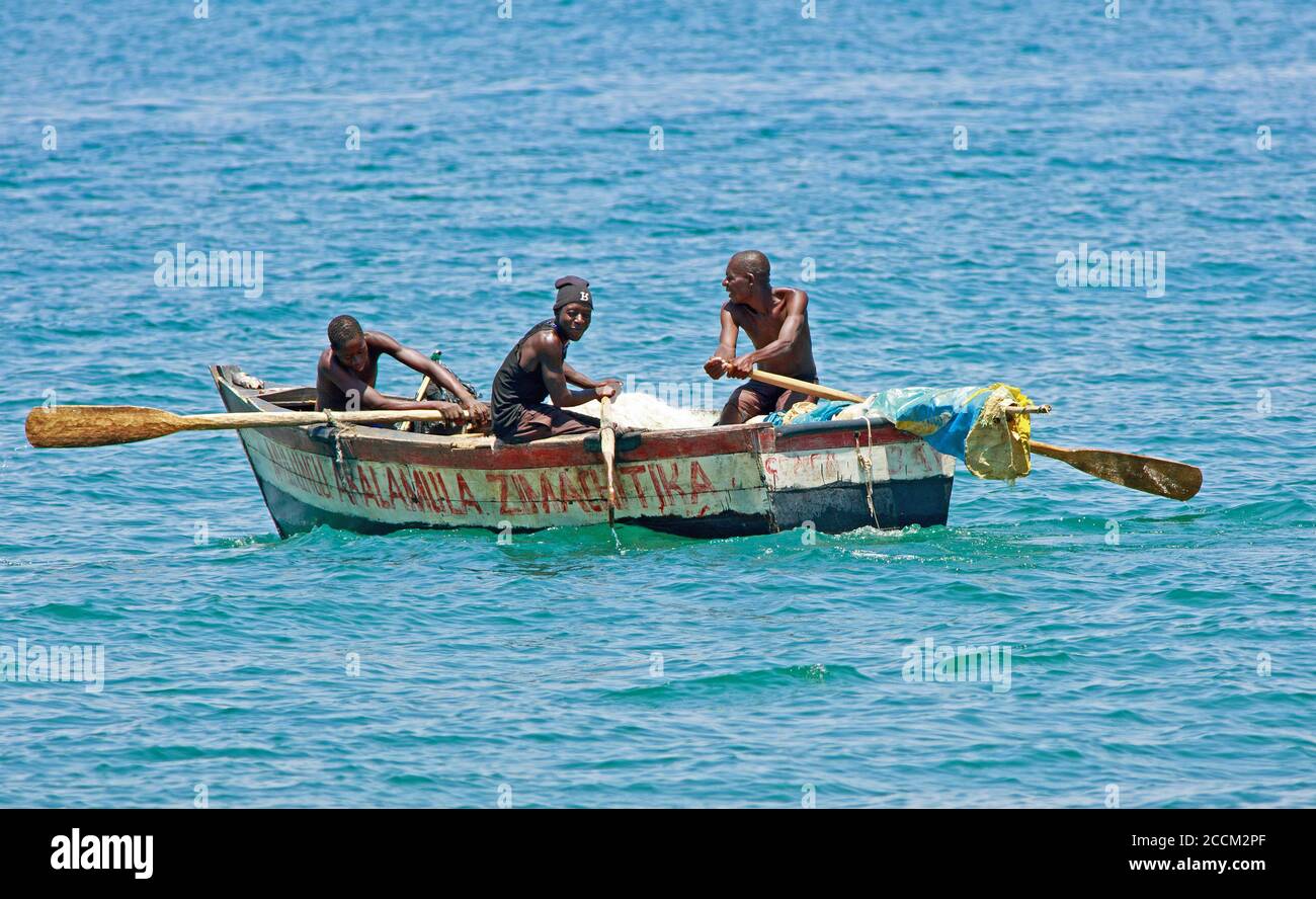 Lake Malawi, 2017.  Local African Fishermen in a wooden rowing boat.  Fishing on Lake Malawi by locals is common, as it provides the local people with Stock Photo