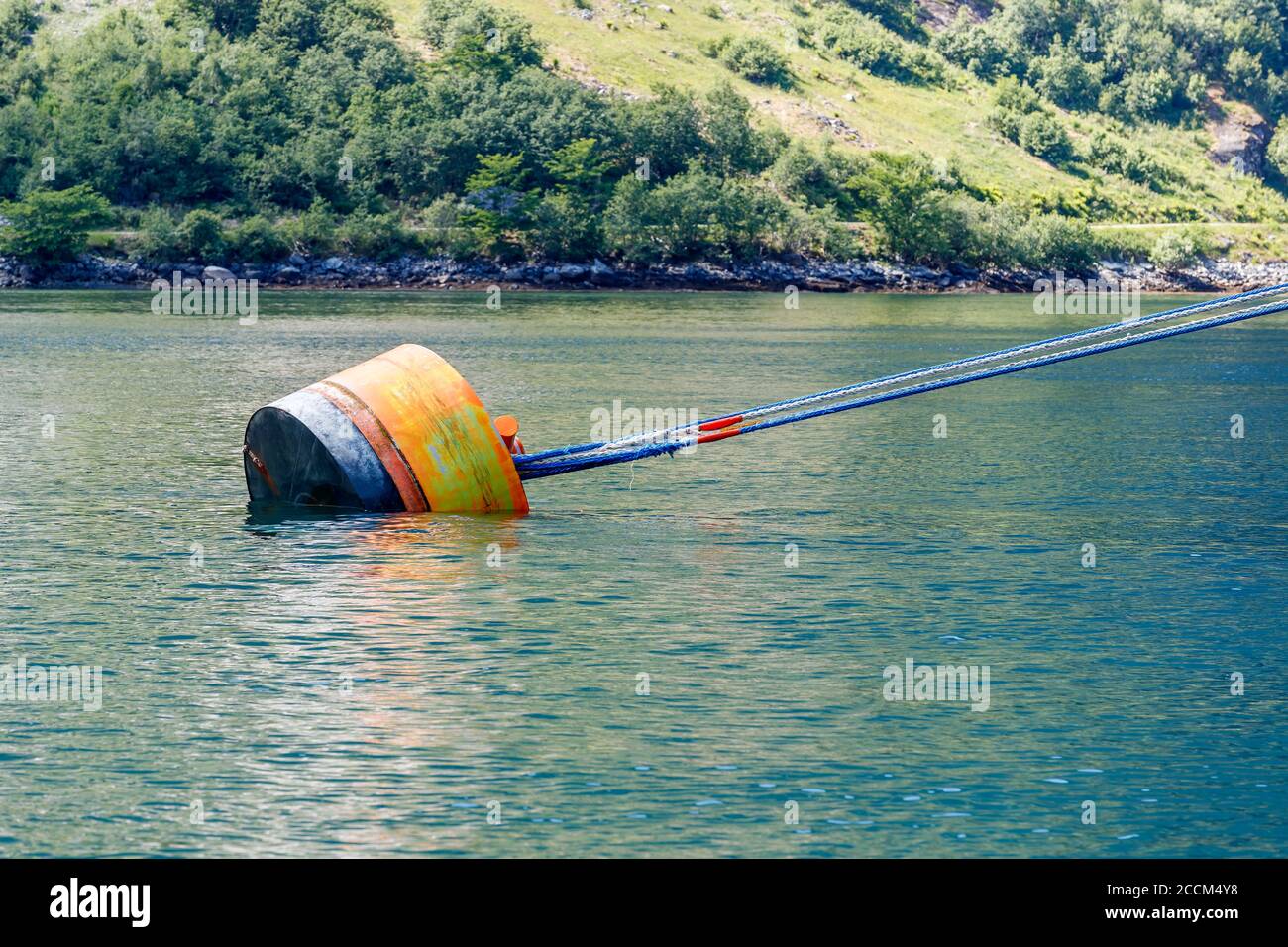 GEIRANGER, NORWAY - 2016 JUNE 14. Ship tied to a mooring Buoy with mooring ropes. Stock Photo