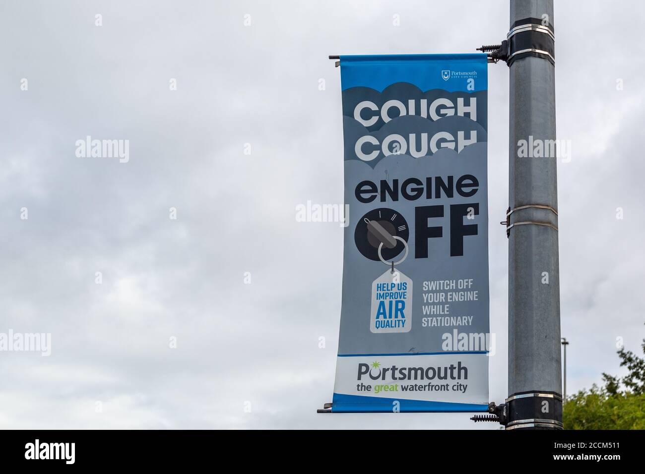 A sign on a lamppost promoting cleaner air with the slogan cough cough engine off Stock Photo