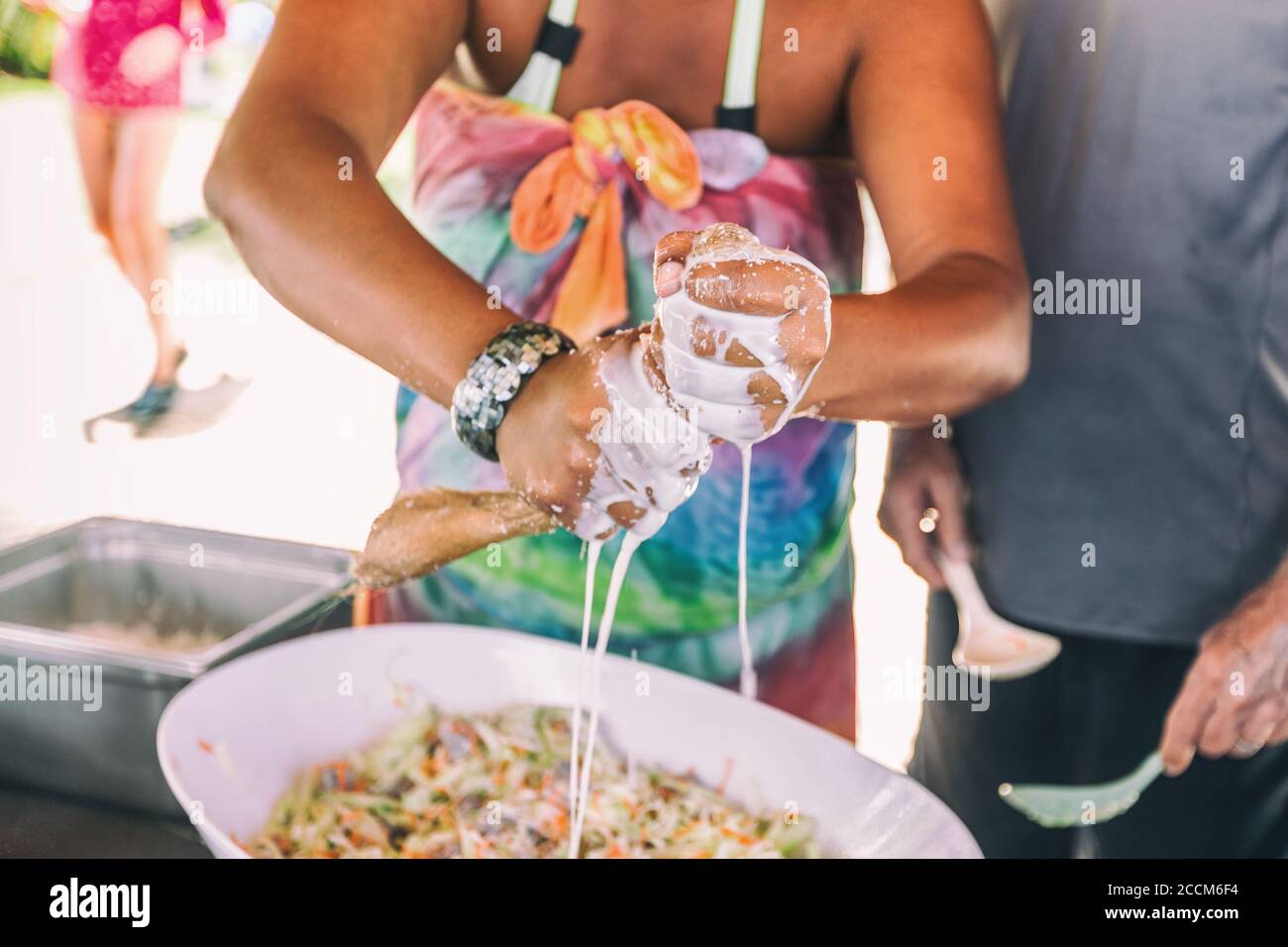 Coconut milk fresh pressed handmade. Woman making homemade recipe pressing natural coconut with hands to demonstrate Polynesian culture, local typical Stock Photo