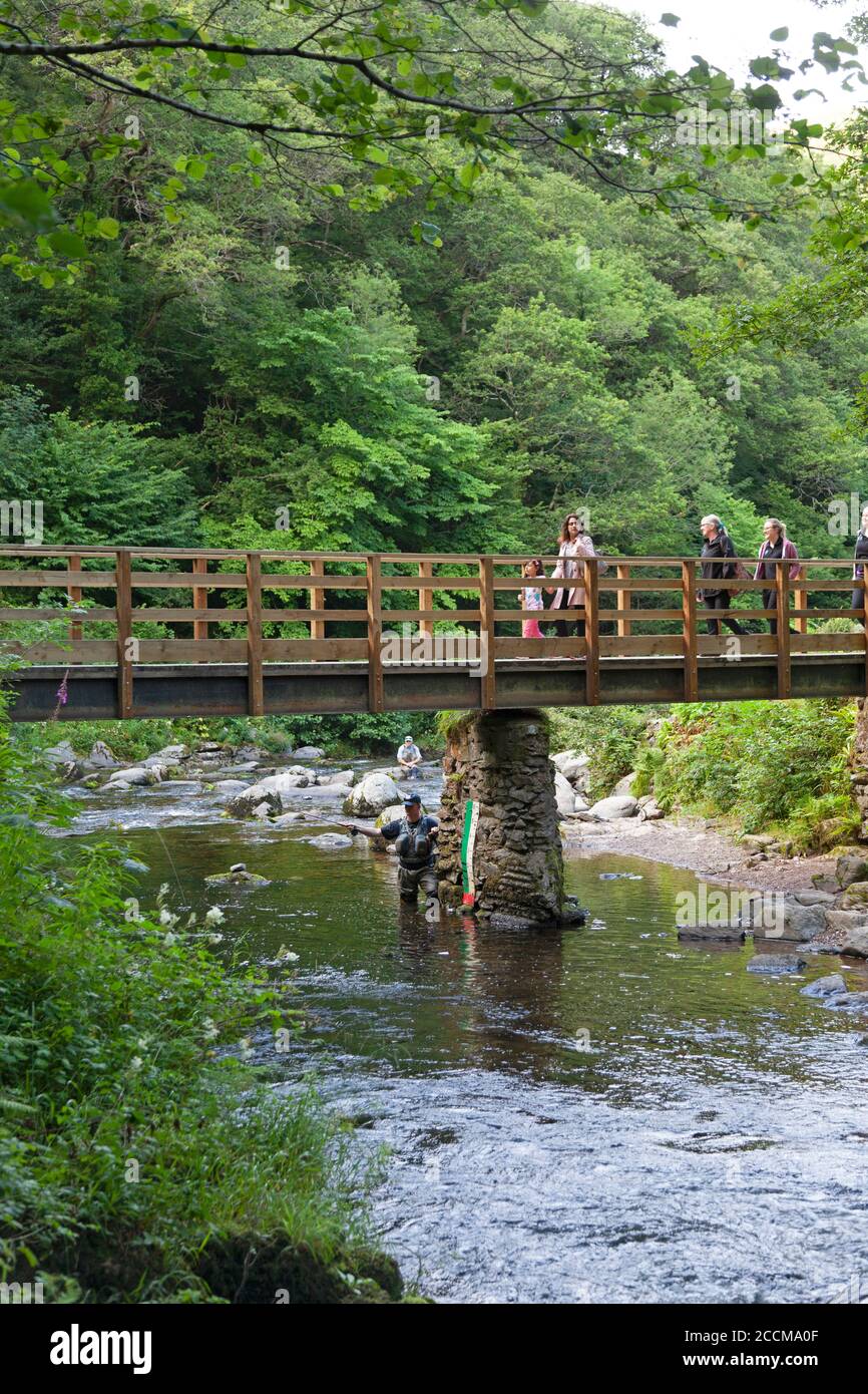 Fishermen and walkers at the bridge where Watersmeet on the east Lyn River, Lynmouth in North Devon Stock Photo