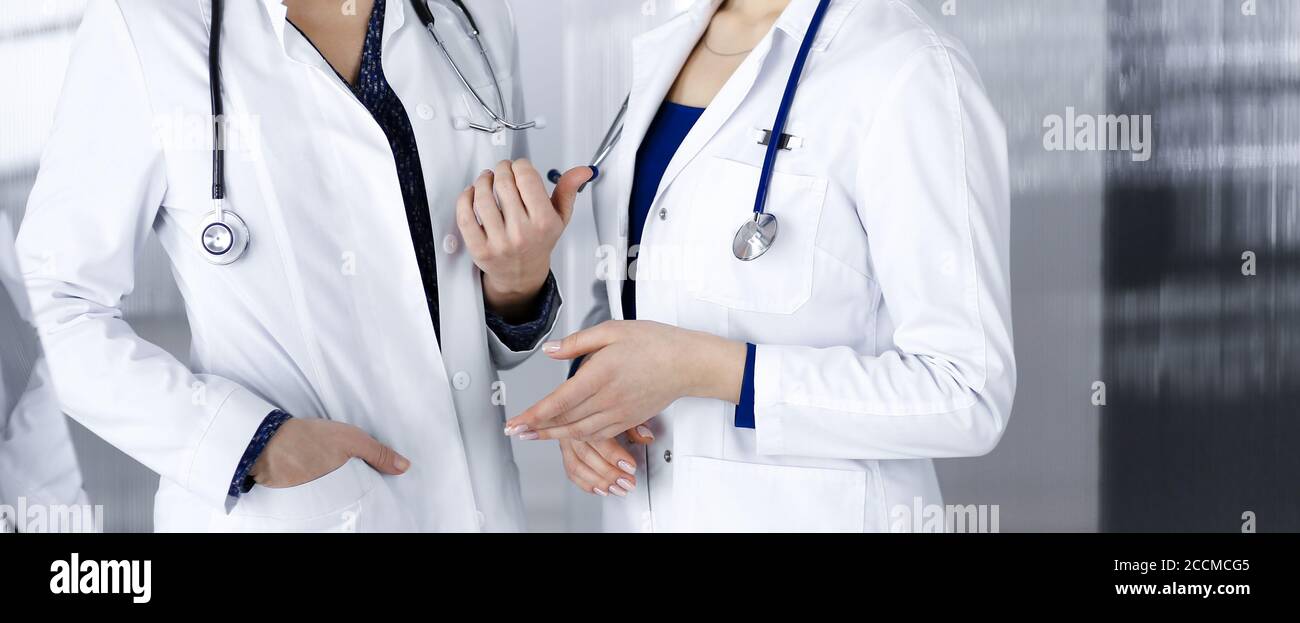 Two Physicians Two female physicians are discussing medical therapy, while standing at ...