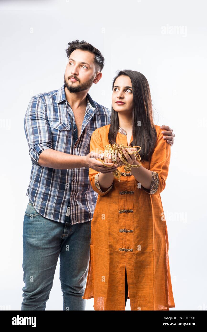 Indian couple holding gold jewelry, ornaments - Asset or Gold Loan concept Stock Photo