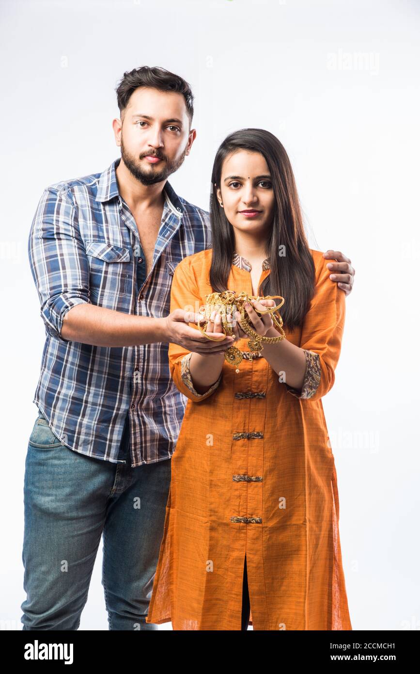 Indian couple holding gold jewelry, ornaments - Asset or Gold Loan concept Stock Photo