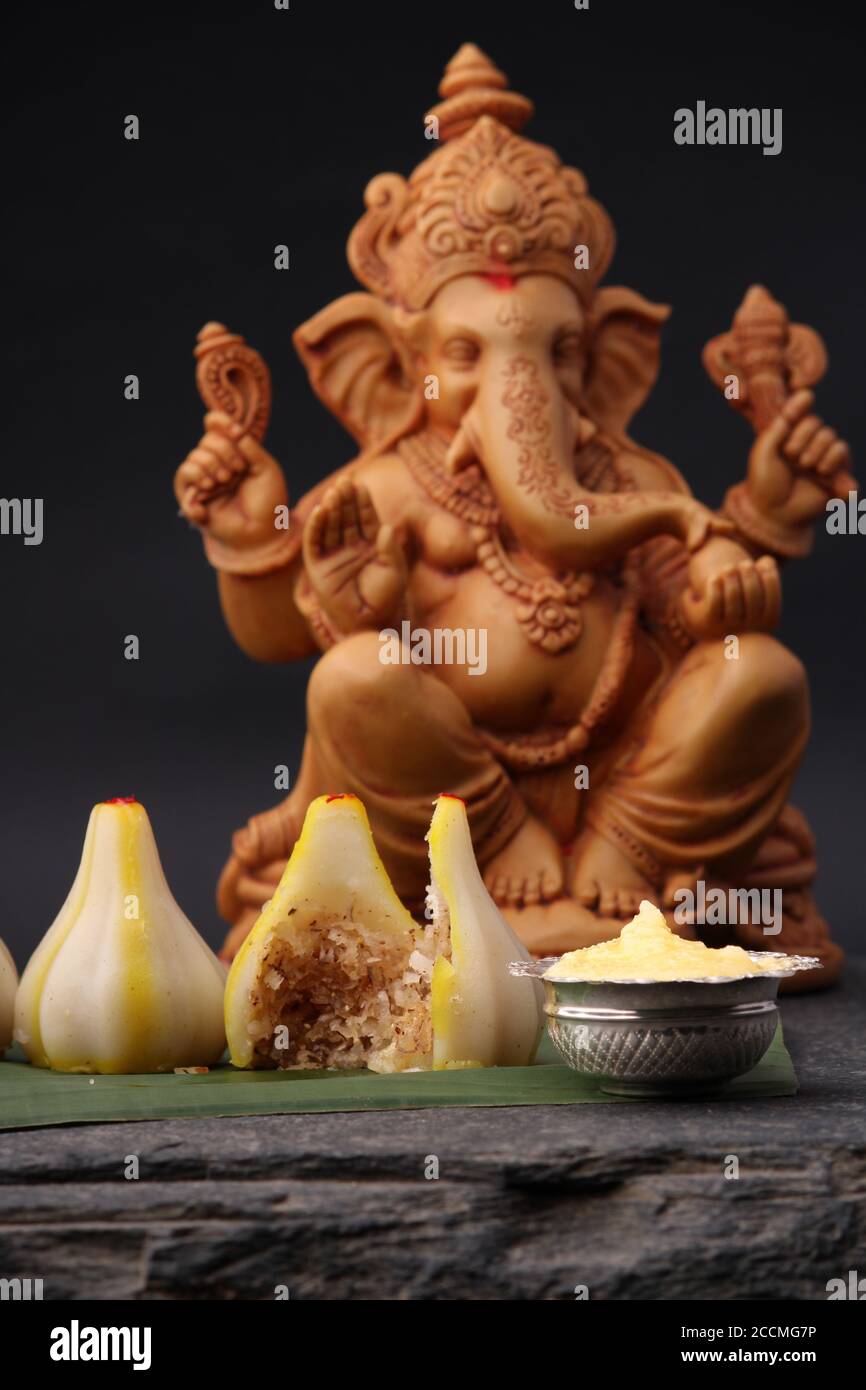 Modak- a traditional dish made on Ganpati festival in India. served with  clarified butter. Ganesh idol at background Stock Photo - Alamy