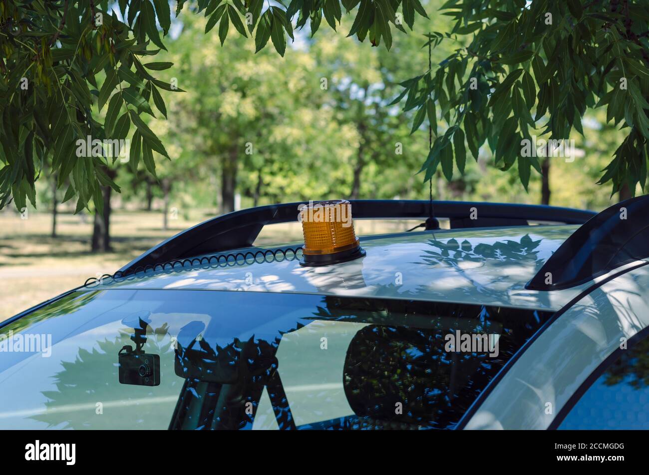 Orange siren on the roof of the car. A specially equipped car is parked  outside in the shade of an ash tree. Commercial security services. Without  peo Stock Photo - Alamy