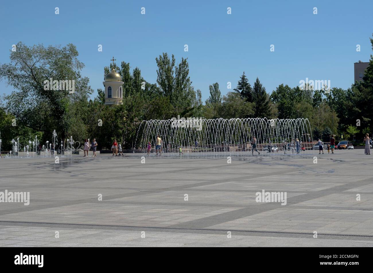Nikolaev, Ukraine - August 17, 2020: People with children are resting on the city square with fountains. Hot summer day. Travel, tourism.ì Stock Photo
