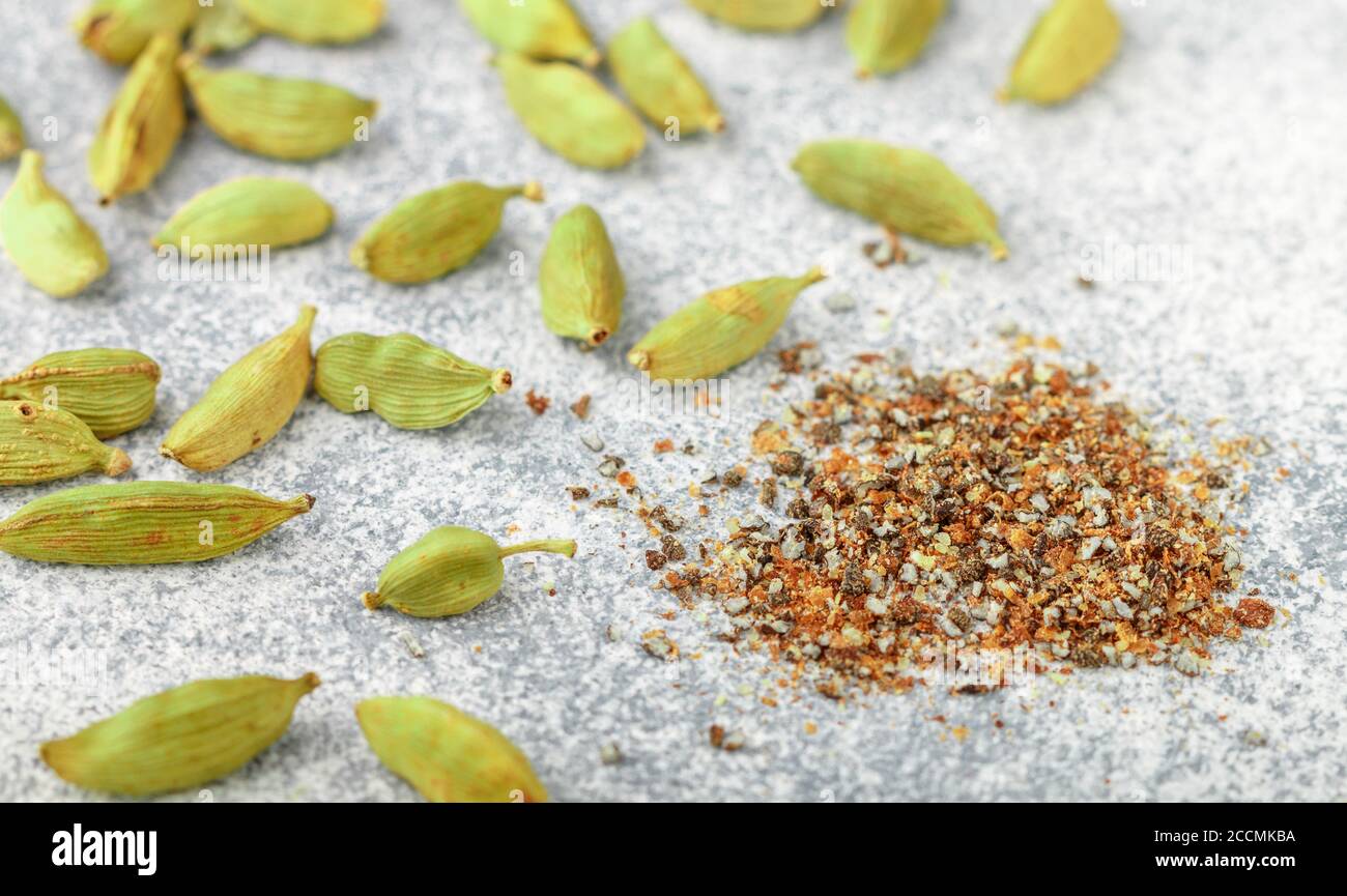 Ground cardamom seeds and whole pods closeup. Seasonings and spices
