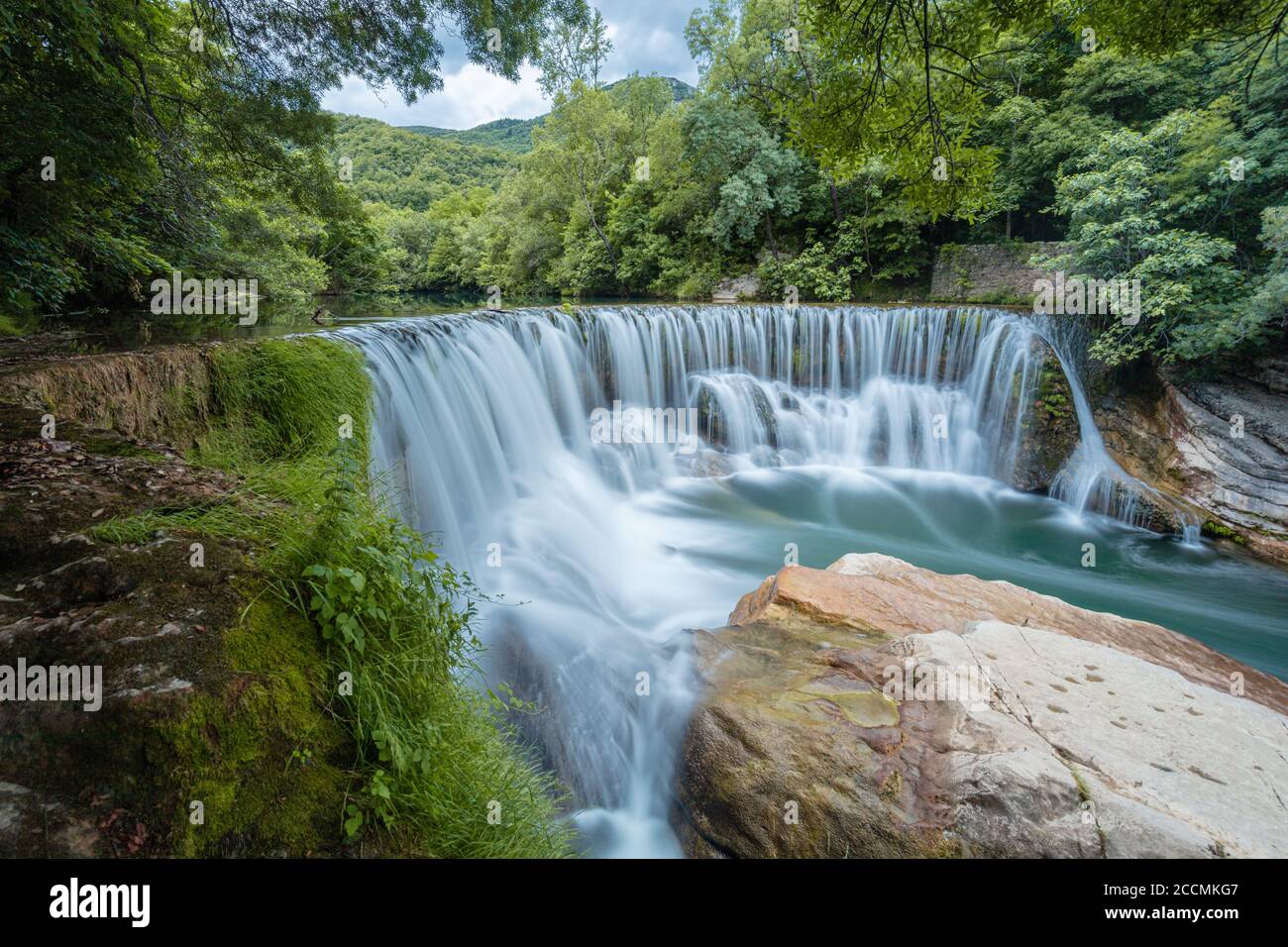 Early June at the Cascade de Saint Laurent Le Minier, waters flows over the modified water fall put in place to control the flow of the River Vis Stock Photo