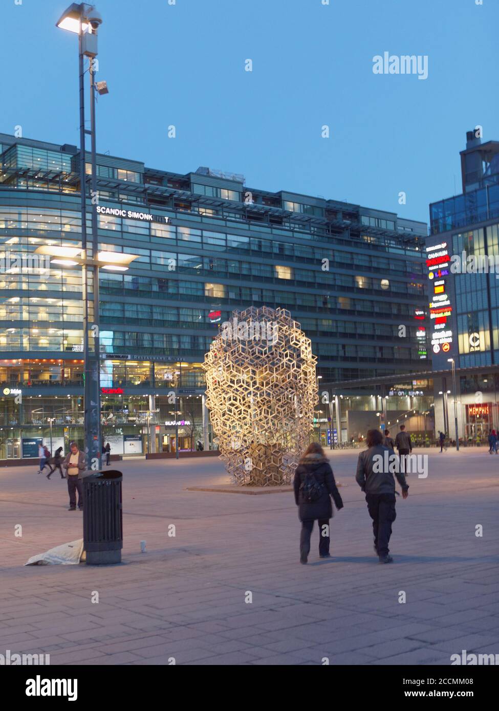 Night view to Narinkka square in Kamppi, Helsinki, Finland, with the Entrepreneurs monument designed by artist Eva Löfdahl in the centre Stock Photo