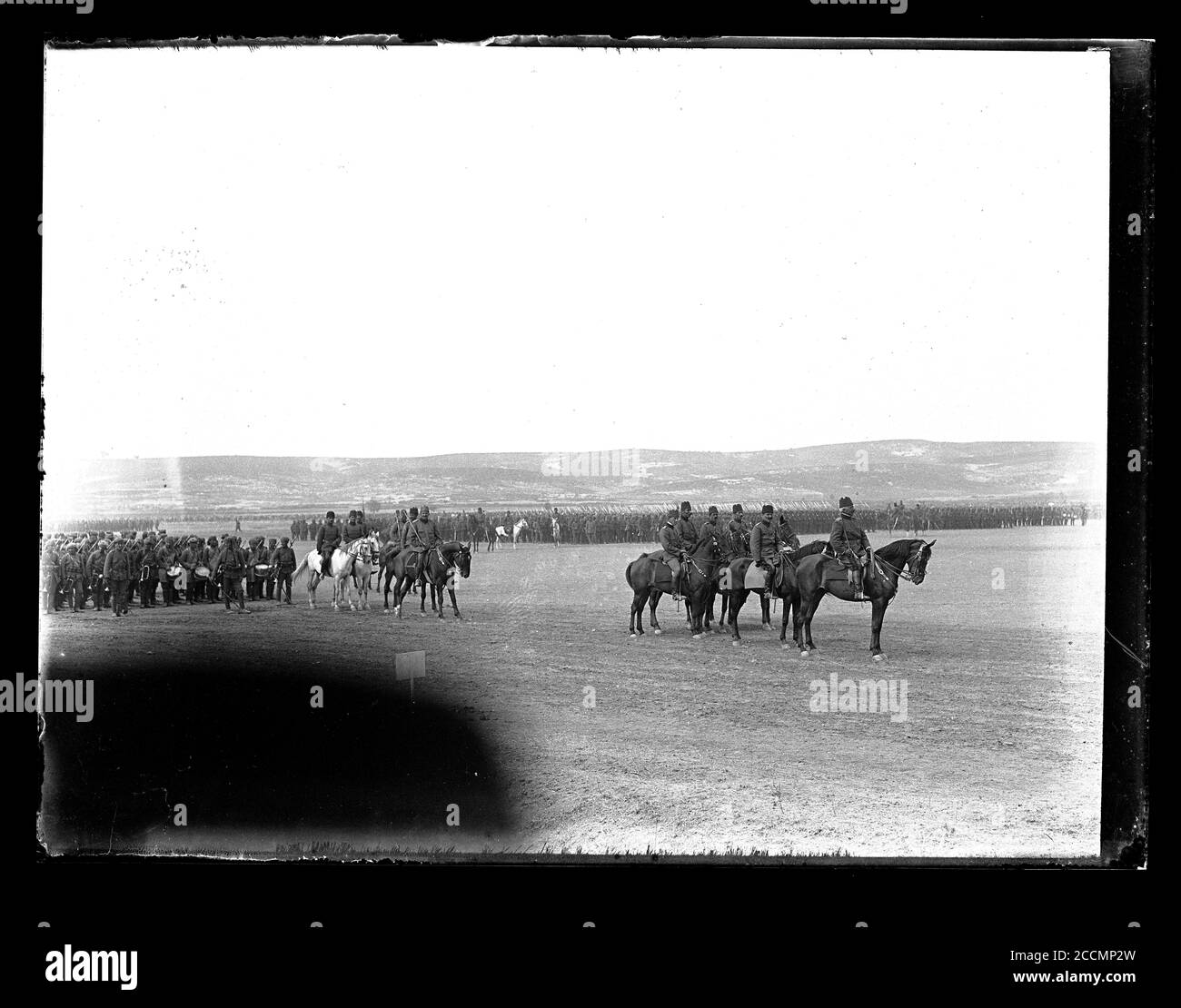 Ottoman infantry preparing for parade with German General Field Marshal Colmar von der Goltz on horseback. Goltz is accompanied by a group of four Turkish and one German officer. Soldiers in the music formation on the left wear headwraps and puttees. Photograph on dry glass plate from the Herry W. Schaefer collection, around 1913. Stock Photo