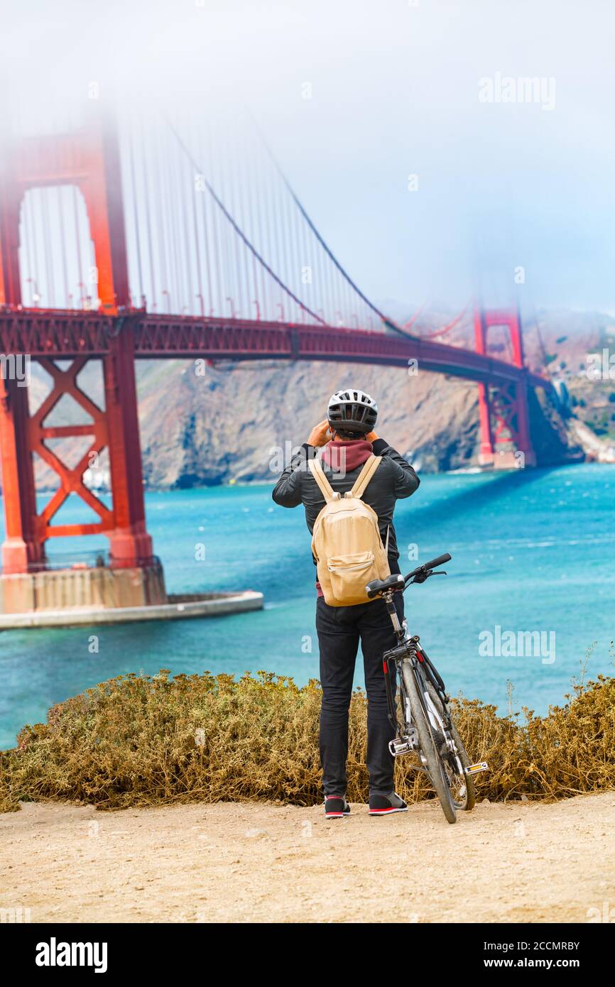 San Francisco Golden Gate Bridge biking tourist with bicycle taking pictures of view on West Coast, California, United States of America. USA travel Stock Photo