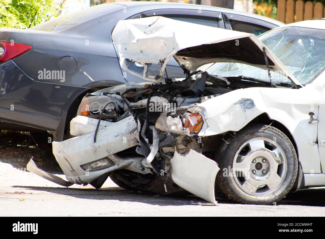 A road accident, a car that crashed, a white car on the road, cracks in