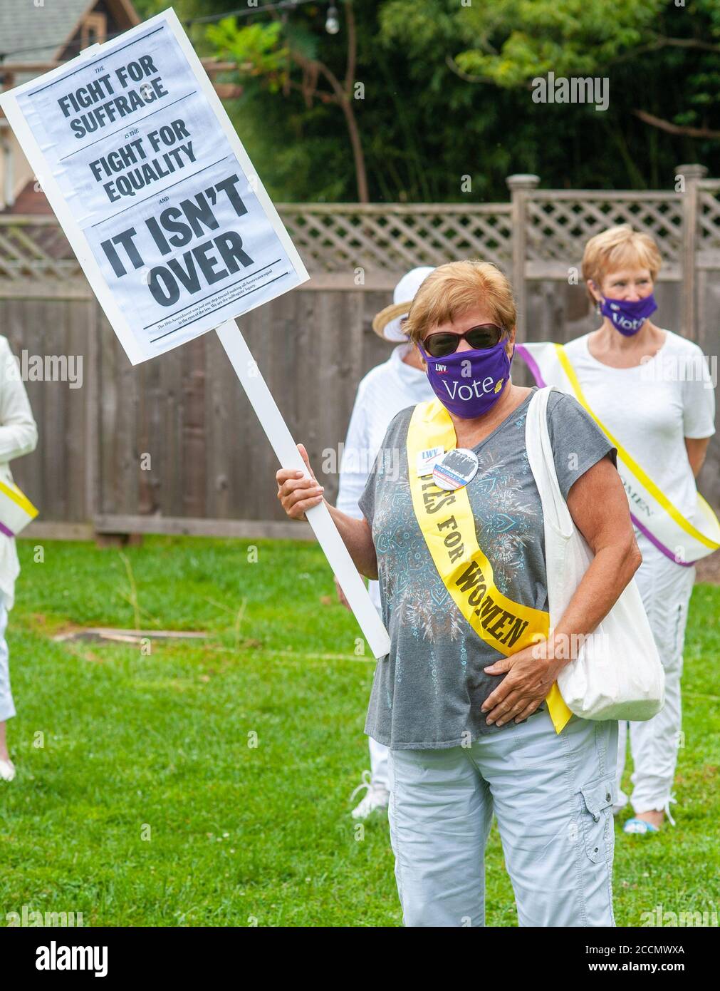 Lumberville, Pennsylvania, USA. 23rd Aug, 2020. Elaine Rafferty of Lawrenceville, NJ holds a sign during a 'Passing of the Suffrage Torch' event in which members of both Leagues will walk out on the Lumberville C Raven Rock Bridge to meet one another; our League will then pass across a replica suffrage torch Sunday, August 23, 2020 at Lumberville Bridge in Lumberville, Pennsylvania. This symbolic event is honoring the work of the suffragists and recalling the WomenÕs Political Union 1915 campaign for the right to vote, during which a torch was carried through New York and New Jersey by members Stock Photo