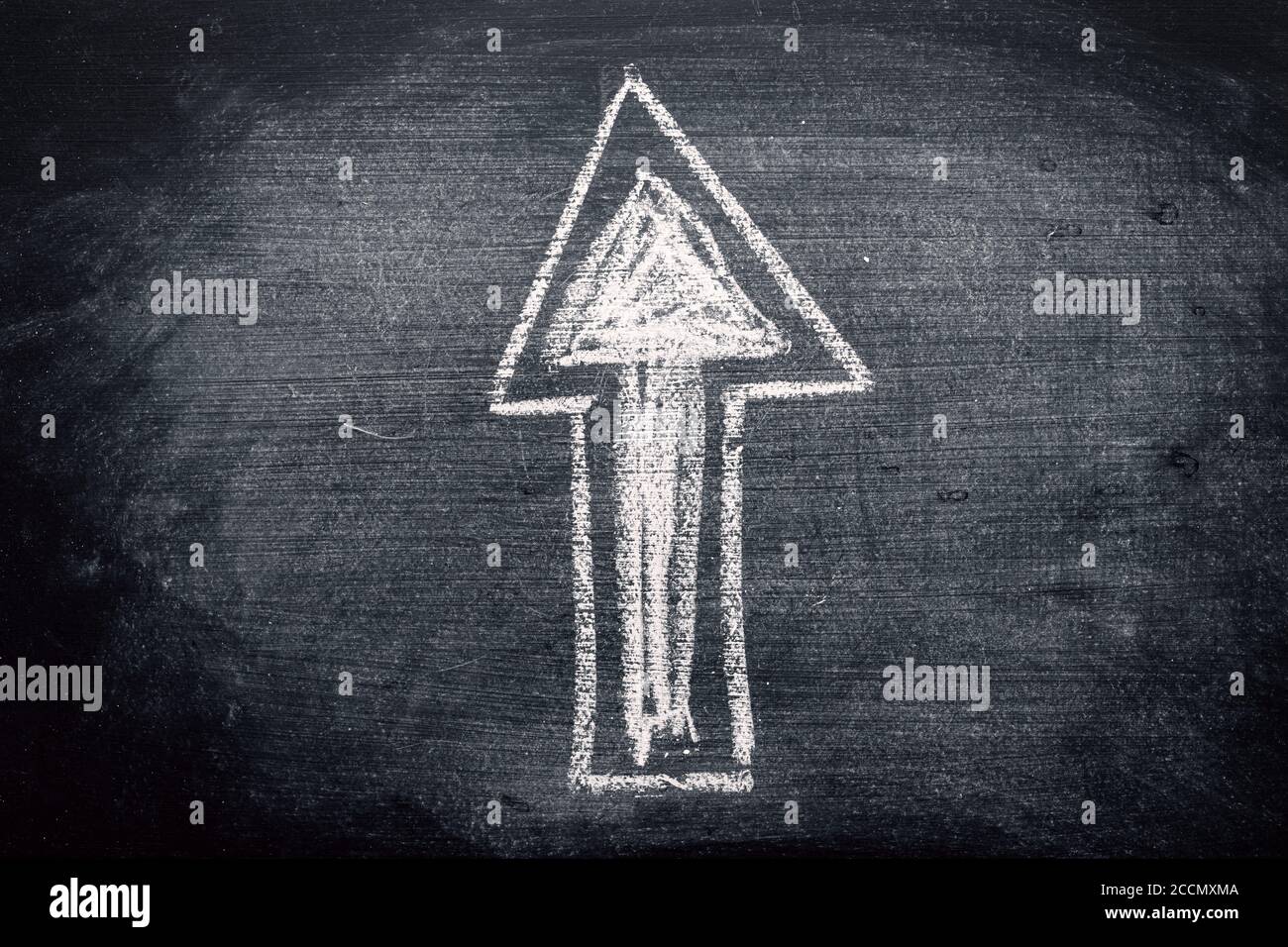 Arrow symbol, chalk on dirty blackboard. Concept of choosing the right direction in education. Stock Photo