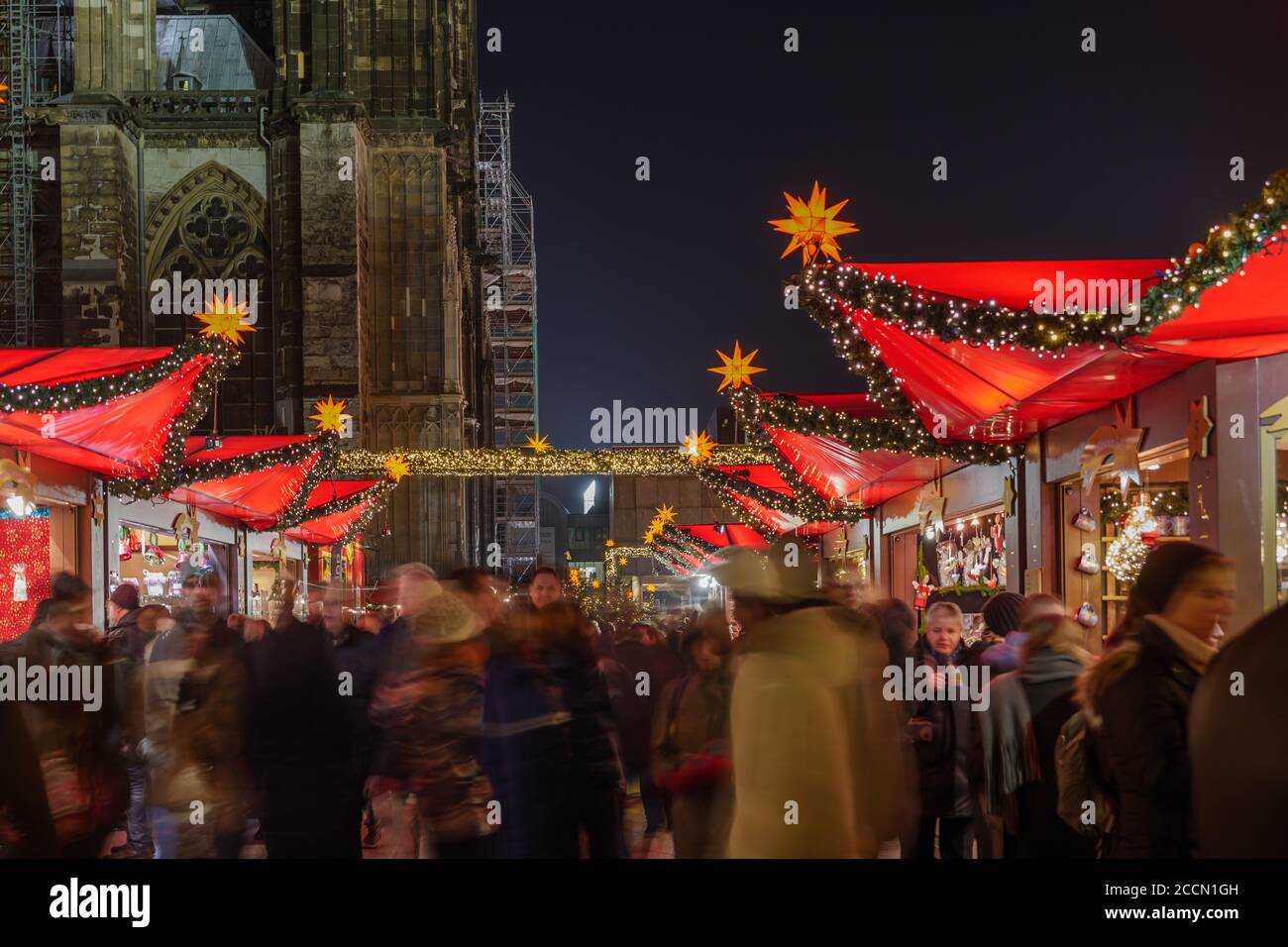 Night scenery, Weihnachtsmarkt, Christmas Market in Köln, with various decorated illuminate stalls in front of Christmas tree and Cologne Cathedral. Stock Photo
