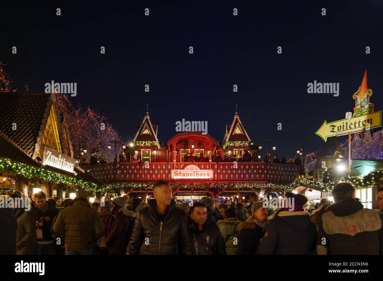 Night atmosphere with crowd of people surrounded with beer house at Heumarkt, famous Christmas market square in Köln. Stock Photo