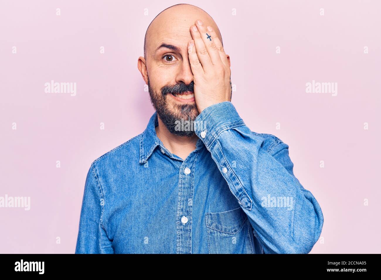 Young handsome man wearing casual clothes covering one eye with hand ...