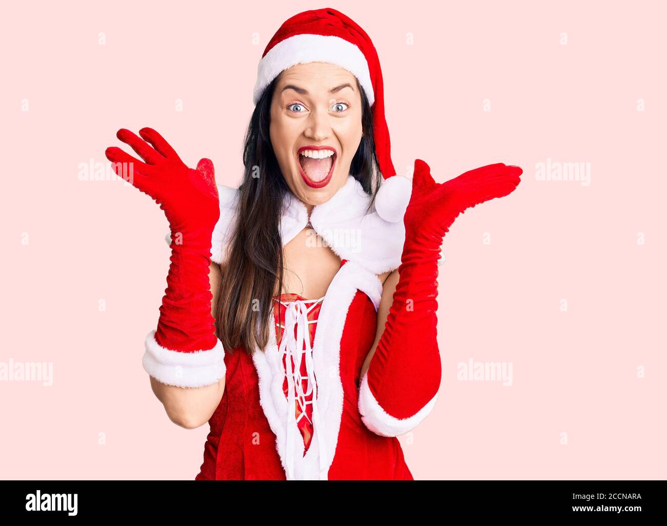 Santa Rased Young beautiful caucasian woman wearing santa claus costume celebrating ...