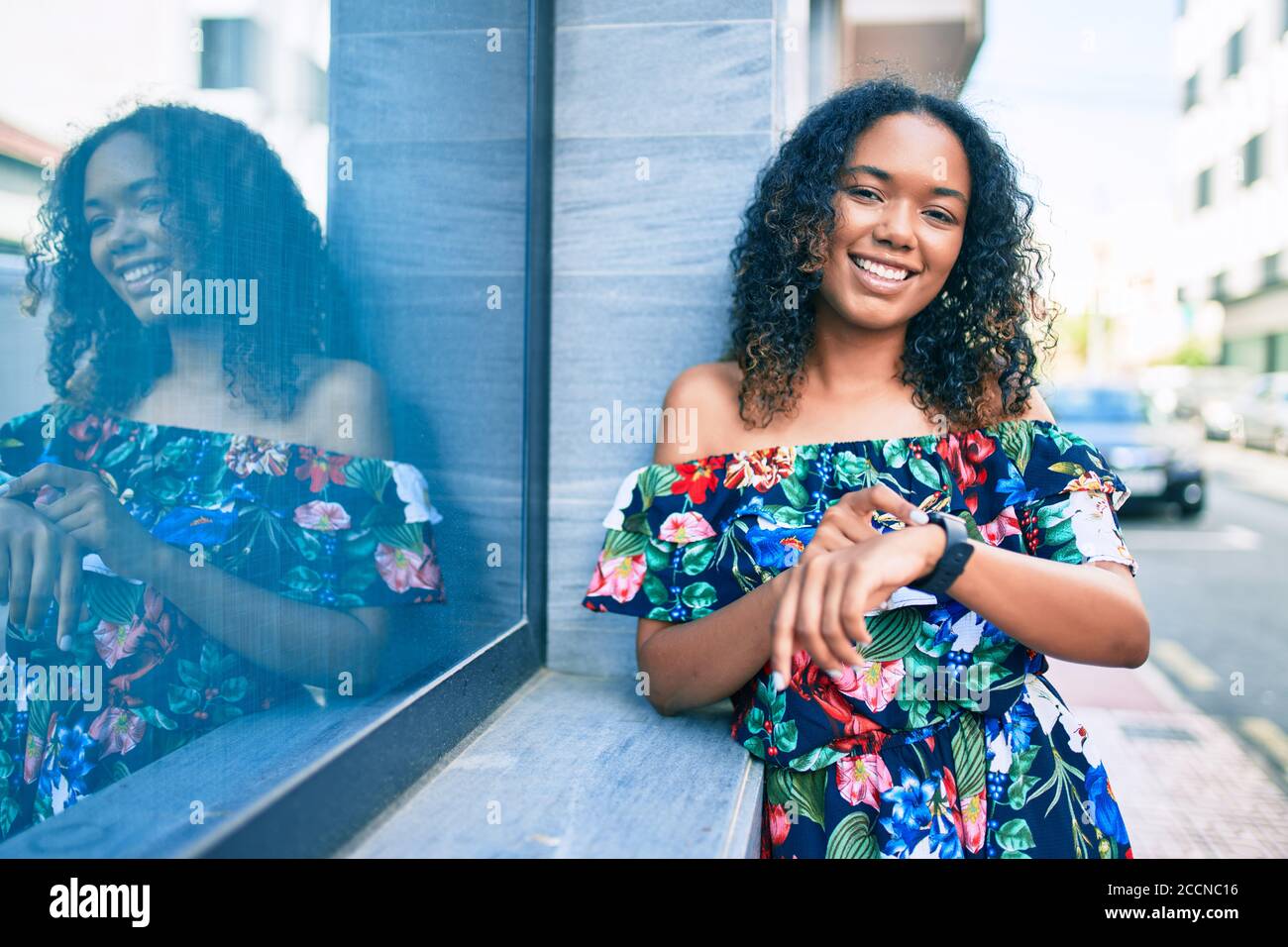 Young african american woman with curly hair smiling happy outdoors ...