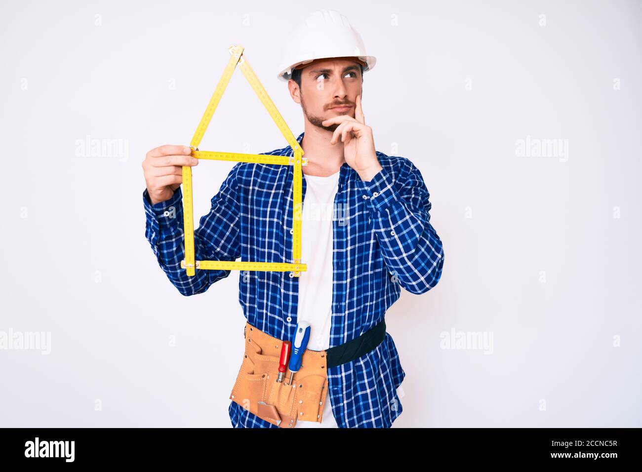 Young handsome man wearing architect hardhat holding build project ...