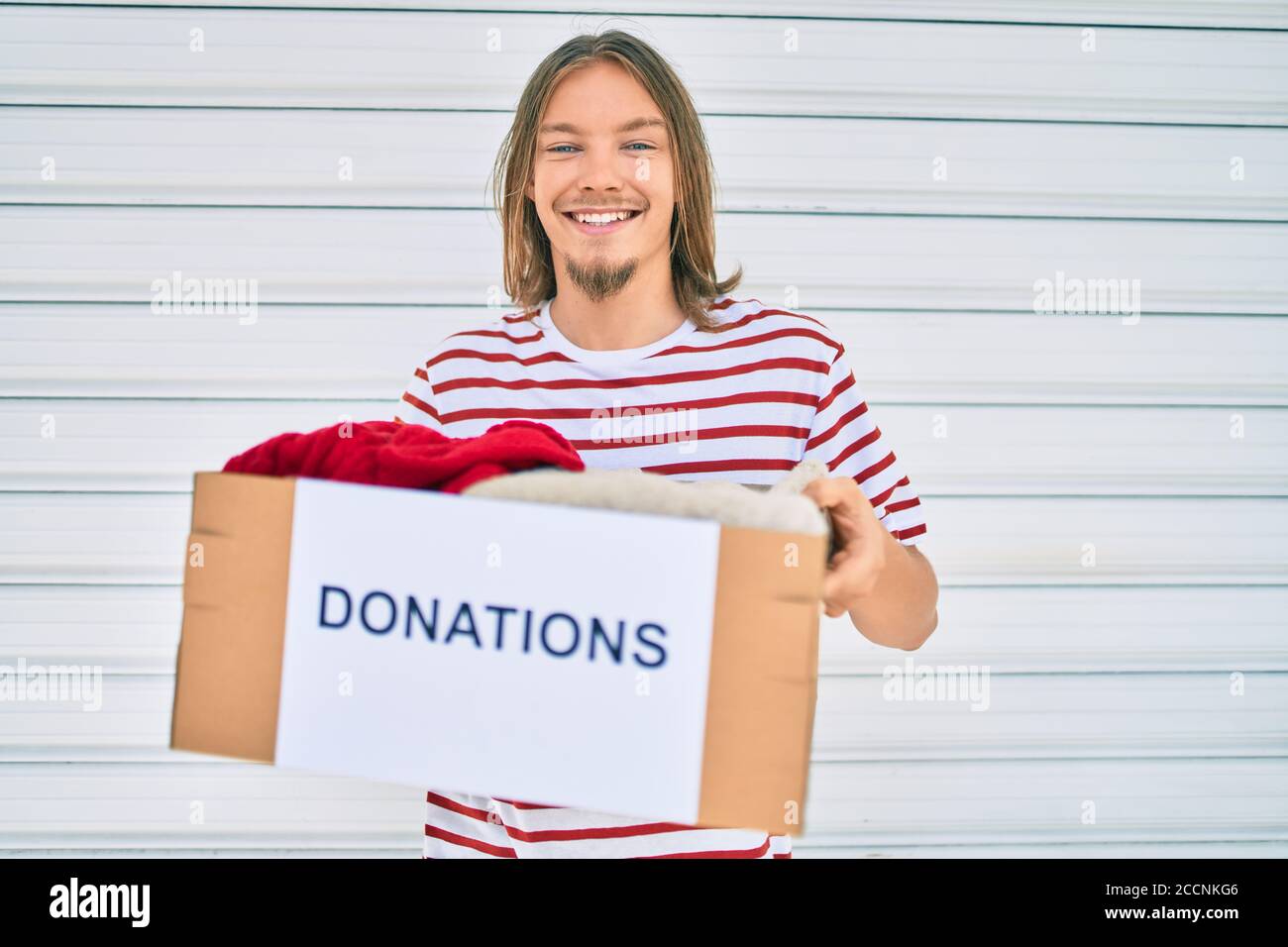https://c8.alamy.com/comp/2CCNKG6/young-caucasian-man-with-blond-long-hair-and-beard-holding-cardboard-box-with-clothes-from-donations-2CCNKG6.jpg