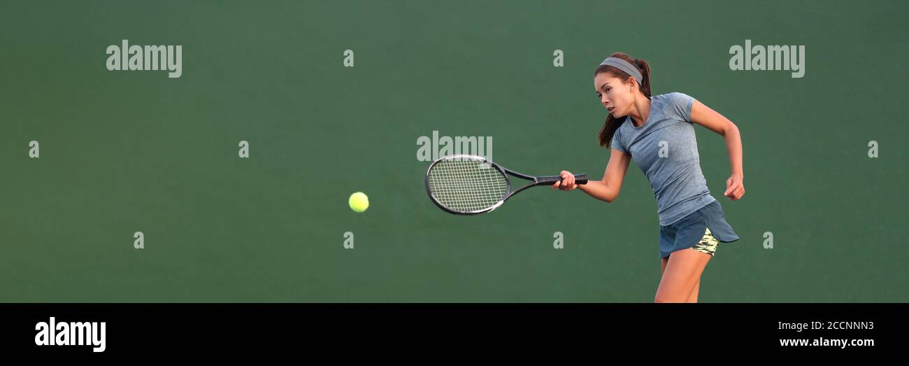 Tennis player Asian woman playing hitting ball on court banner. Copy space panorama crop on green background Stock Photo