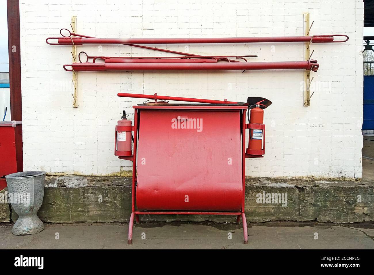 firefighting equipment stand with sandbox, extinguishers, spades and fire hooks Stock Photo