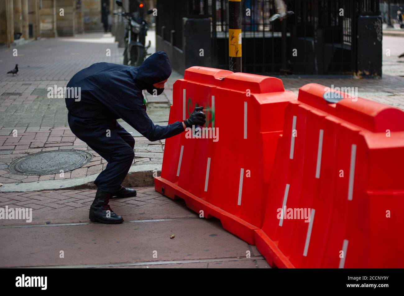 Bogota, Colombia. 23rd Aug, 2020. A demonstrator pains a graffiti on a safety barrier during the Memorial Demonstrations for Dilan Cruz on August 23 2020 in Bogota, Colombia. Dilan Cruz was a high school student who was shot by a riot police officer during the 2019 national strike in Colombia, on the demonstrations that took place on november 23 2019. (Photo by Sebastian Barros Salamanca/Pacific Press) Credit: Pacific Press Media Production Corp./Alamy Live News Stock Photo